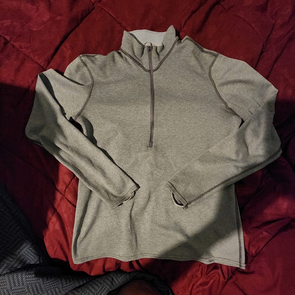 Patagonia gray jacket with half zip front and thumb straps.